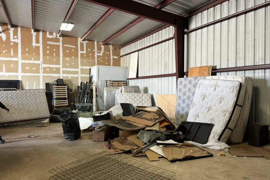 Warehouse cleanout with mattresses, cardboard, and debris staged for removal by Haul and Go
